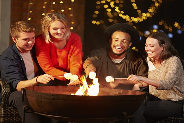 Group Of Friends Toasting Marshmallows By Firepit